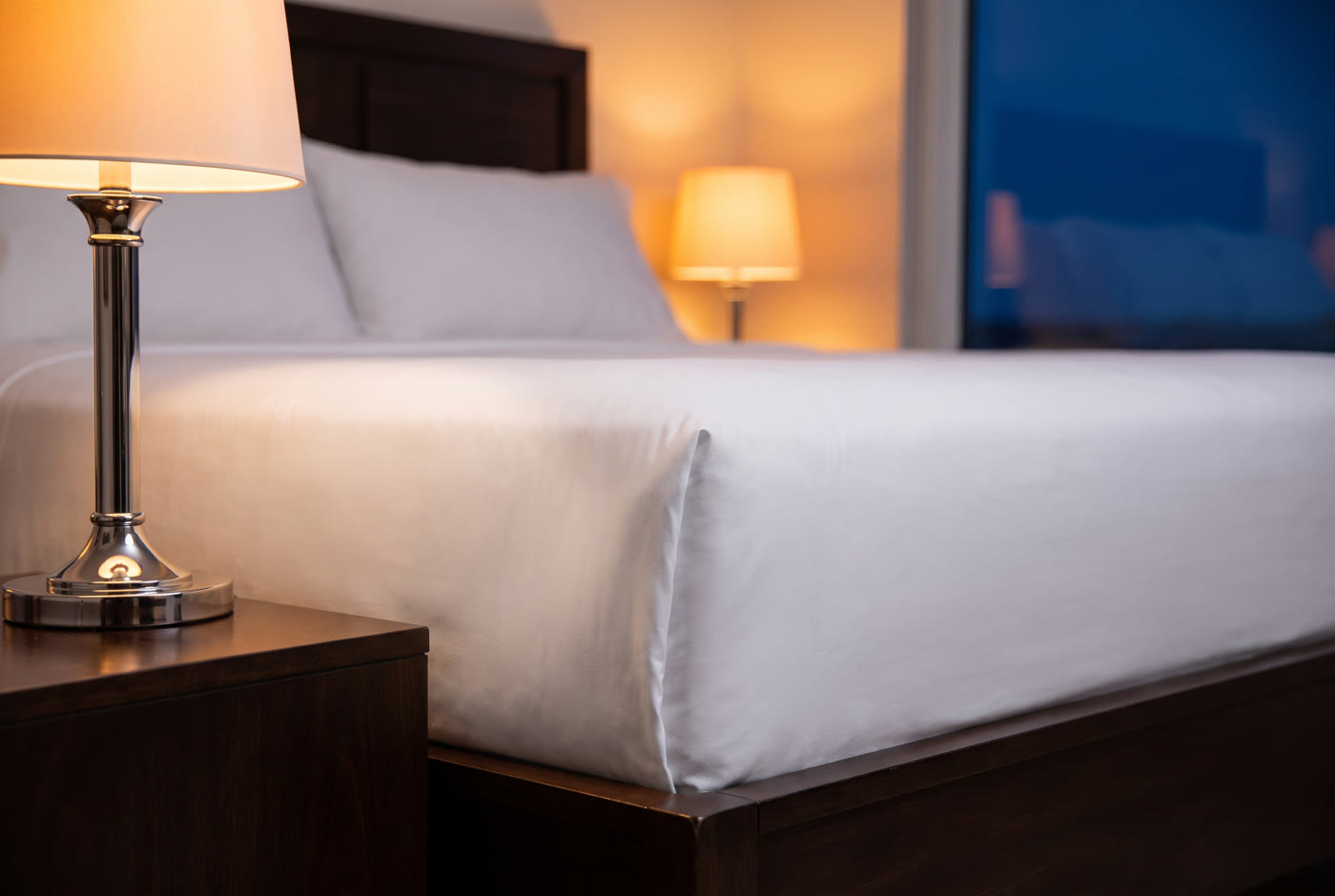Crisp white bed corner with tucked sheets